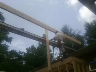 Carpenter setting a ridge beam over a new addition frame — Ice Dam Removal by Roofing Brothers in Wyocena