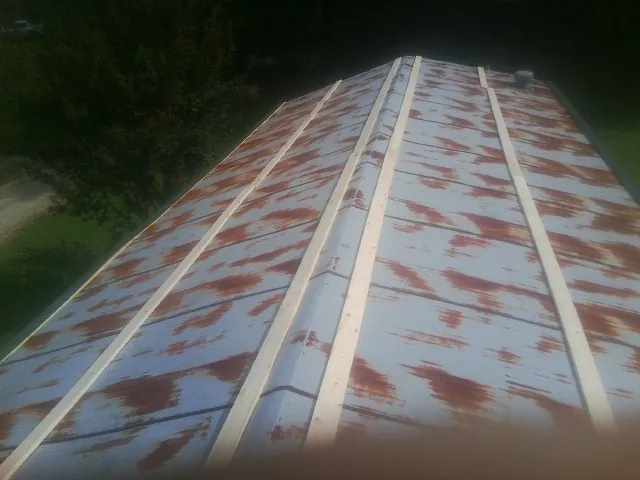 Rusted metal roof panels with new wood purlins before replacement — Storm Damage Roof Repair in Wyocena by Roofing Brothers
