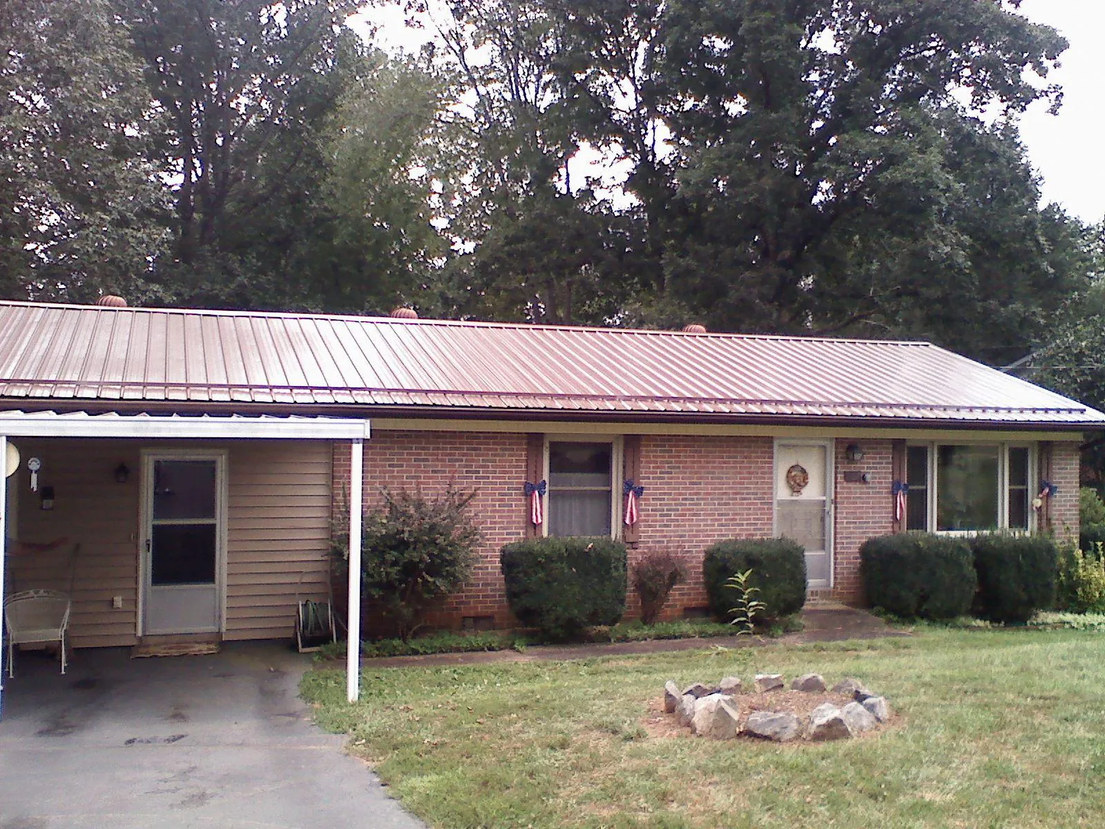 Bronze metal roof and carport on a brick ranch home — Roof Repair work by our crew in Wyocena